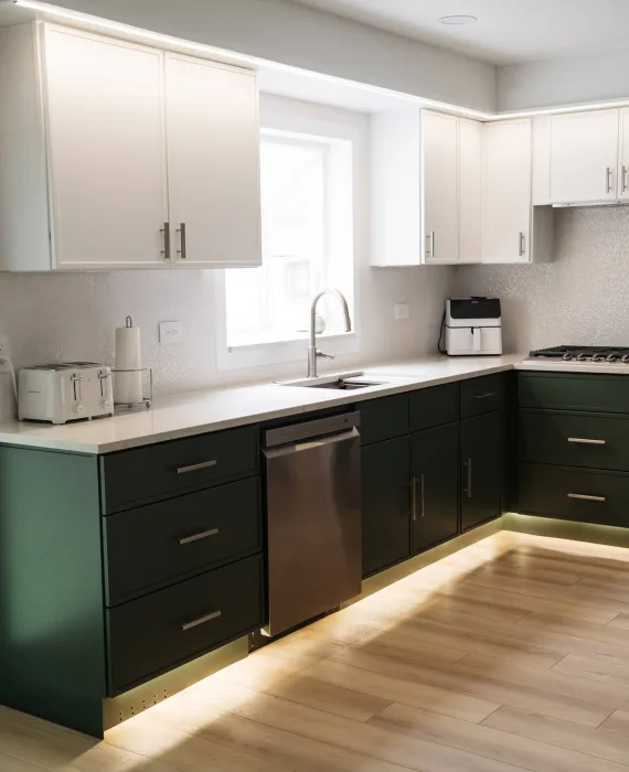 Bright modern kitchen featuring a two-tone cabinet design, large kitchen island, and improved lighting installed as part of the Schaumburg renovation.