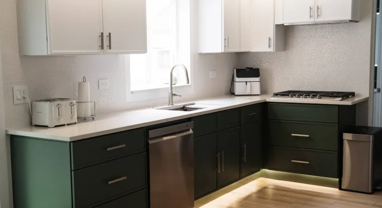 Bright modern kitchen featuring a two-tone cabinet design, large kitchen island, and improved lighting installed as part of the Schaumburg renovation.