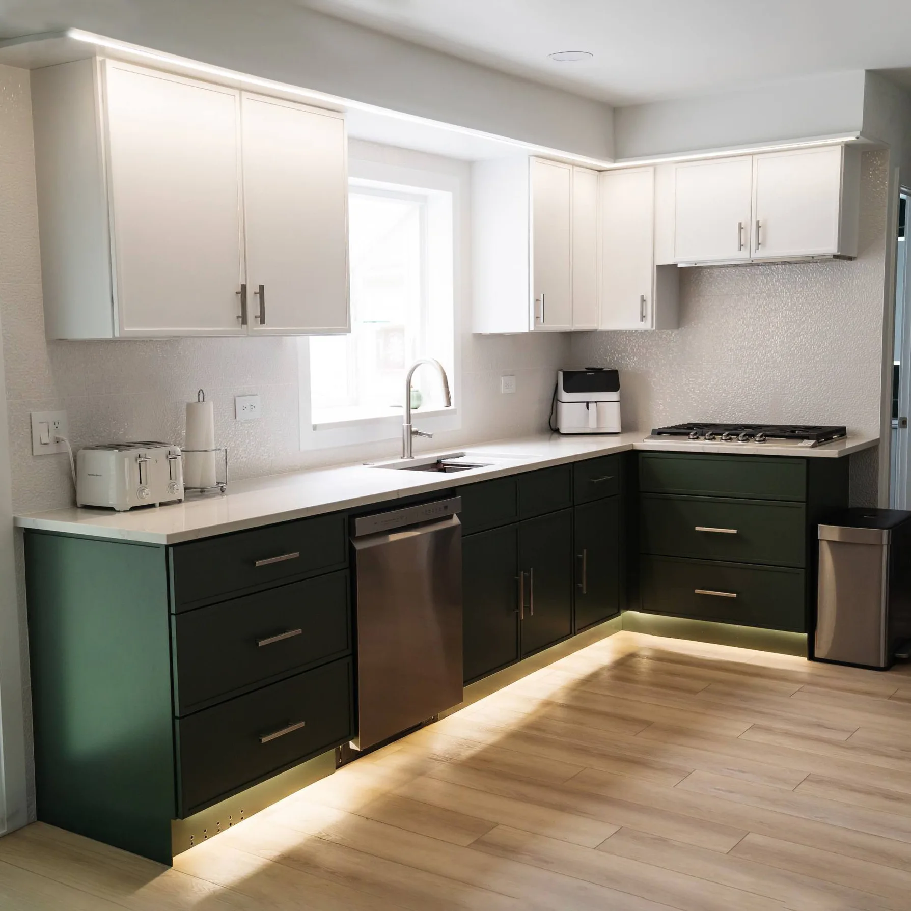 Bright modern kitchen featuring a two-tone cabinet design, large kitchen island, and improved lighting installed as part of the Schaumburg renovation.